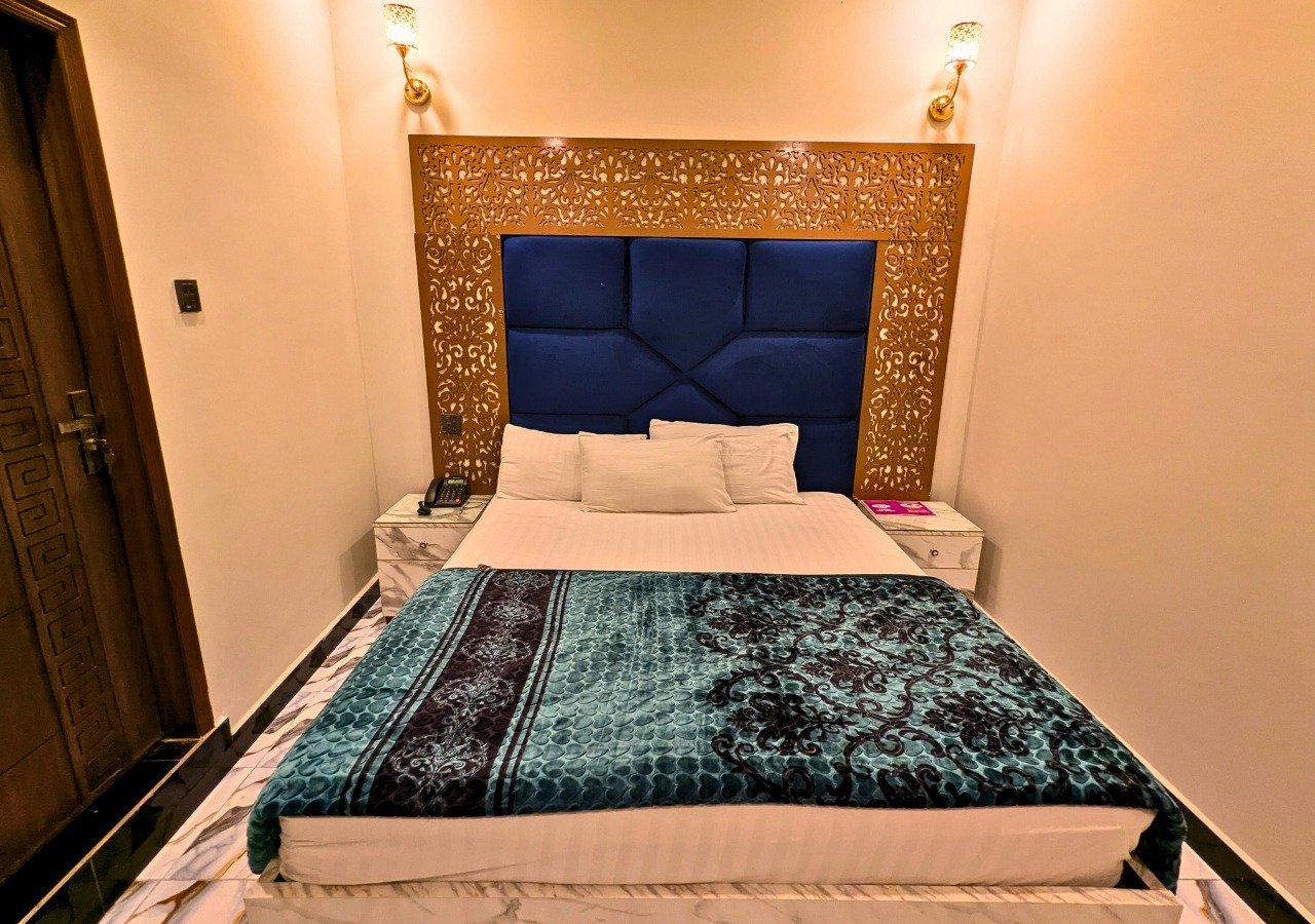 Double Master room with ornate headboard at Dove Inn Executive Hotel